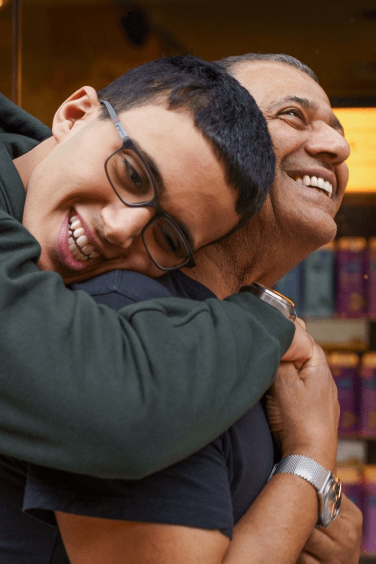 Teen boy hugging dad vertical